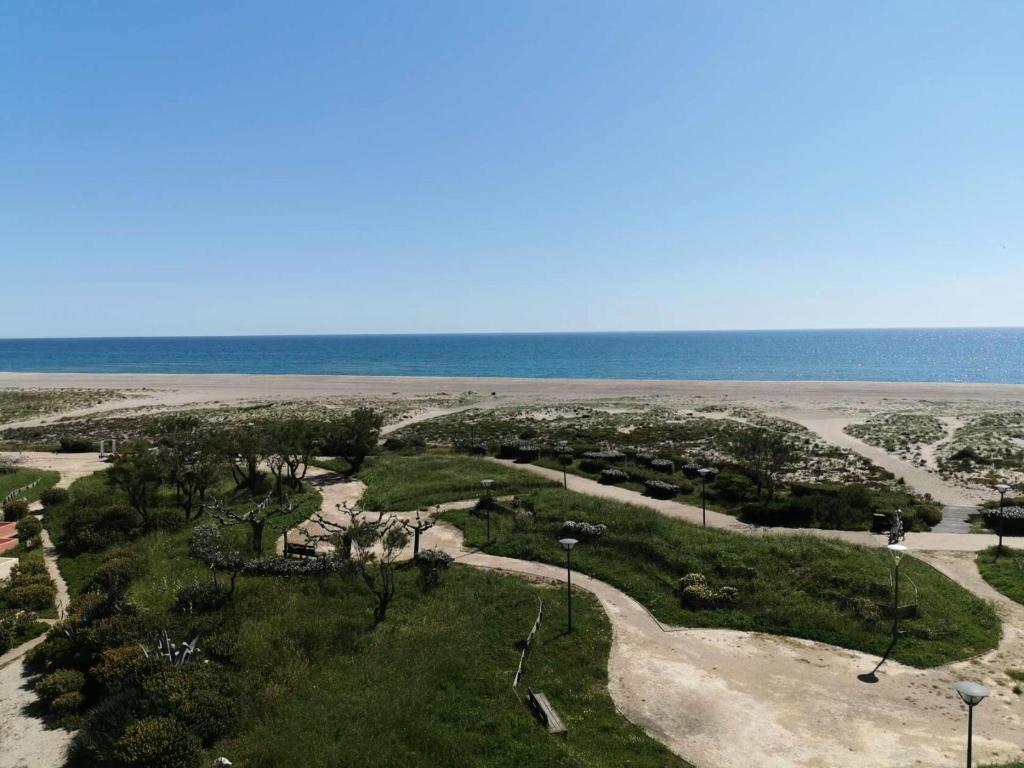 - un parc sur la plage avec l'océan en arrière-plan dans l'établissement Résidence LES NEFS DES SABLES - 2 Pièces pour 5 Personnes 14, à Port-Leucate