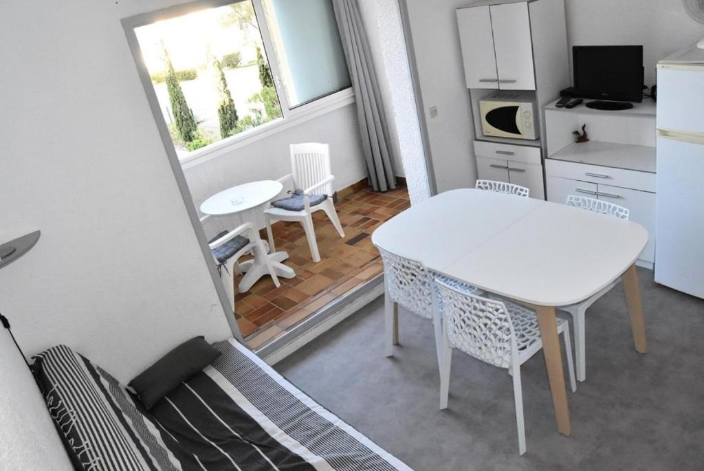 une cuisine et une salle à manger avec une table et des chaises dans l'établissement Résidence PORTES DE LA PLAGE 2 - 2 Pièces pour 4 Personnes 54, à Port-Leucate