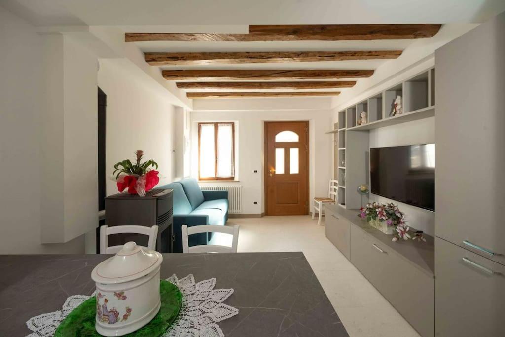 a living room with a table and a living room with a television at Da Elda in Belluno