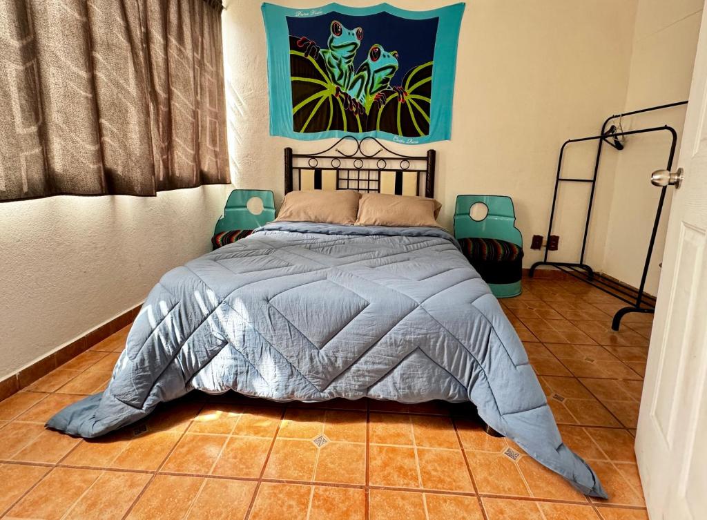 a bedroom with a bed and a painting on the wall at CASA ENTERA PURA VIDA! in Ciudad Hidalgo