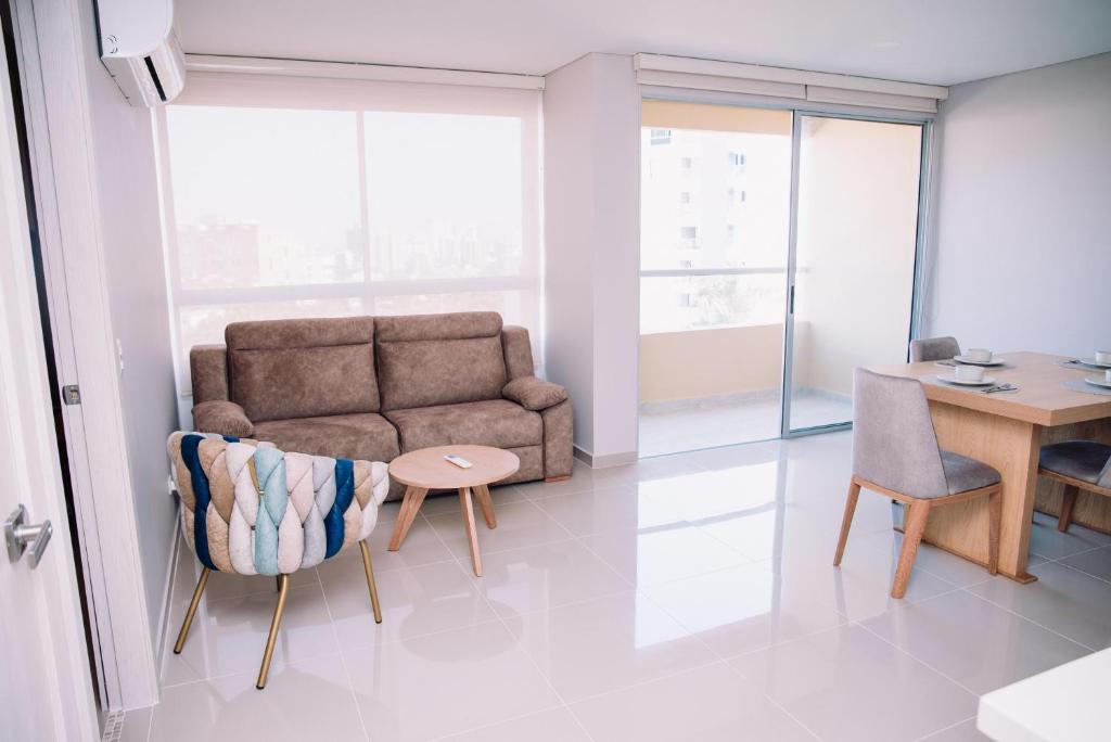 salon z kanapą i stołem w obiekcie Apartaestudio Luxur en Barranquilla w mieście Barranquilla
