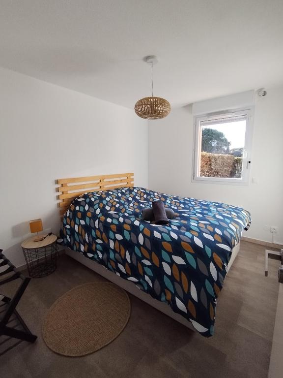um quarto com uma cama com um edredão colorido em t2 spacieux très bien place em Gagnac-sur-Garonne