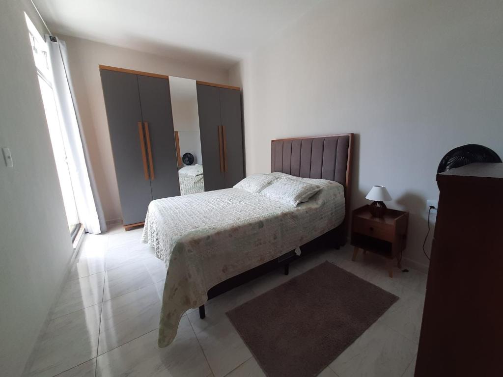 a bedroom with a bed and a wooden headboard at Apartamento Aconchego nas Montanhas, em Cunha-SP in Cunha