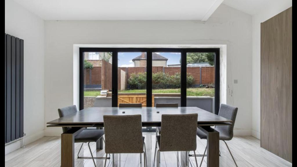 uma sala de jantar com uma mesa de madeira e cadeiras em Newly refurbished 3 bedroom property in north london em East Barnet