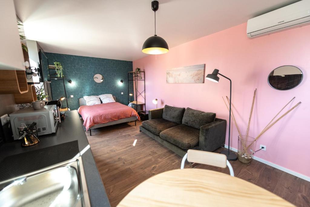 uma sala de estar com um sofá e uma cama em KASA LOUNGE em Rive-de-Gier