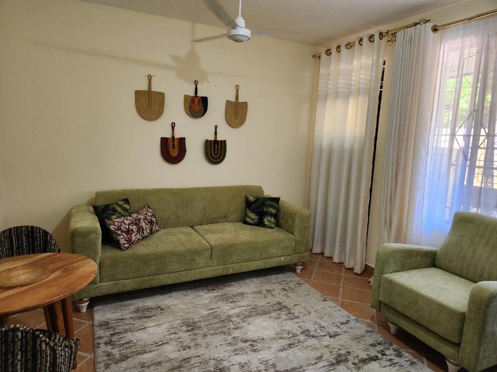 a living room with a green couch and two chairs at Cosy Living near Bofa Beach in Kilifi