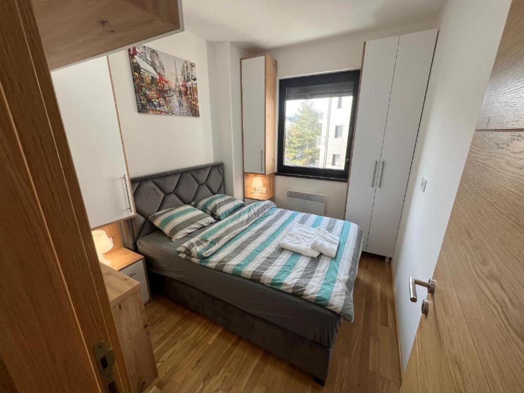 um pequeno quarto com uma cama e uma janela em INNA Zlatibor em Zlatibor