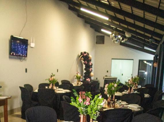 una sala de conferencias con mesas y sillas con flores en Casa de lazer km eventos, en Uberaba