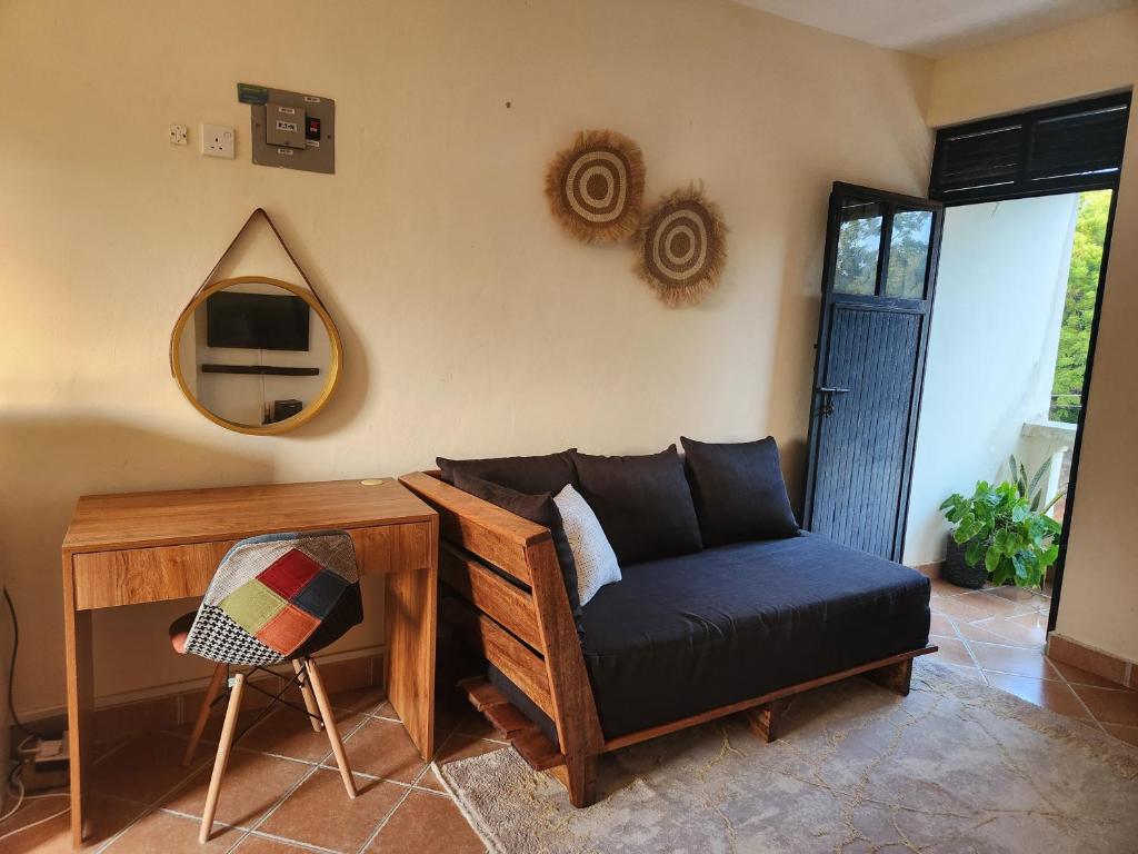 a living room with a couch and a desk and a tv at Adhiambo's Studio near Bofa Beach in Kilifi
