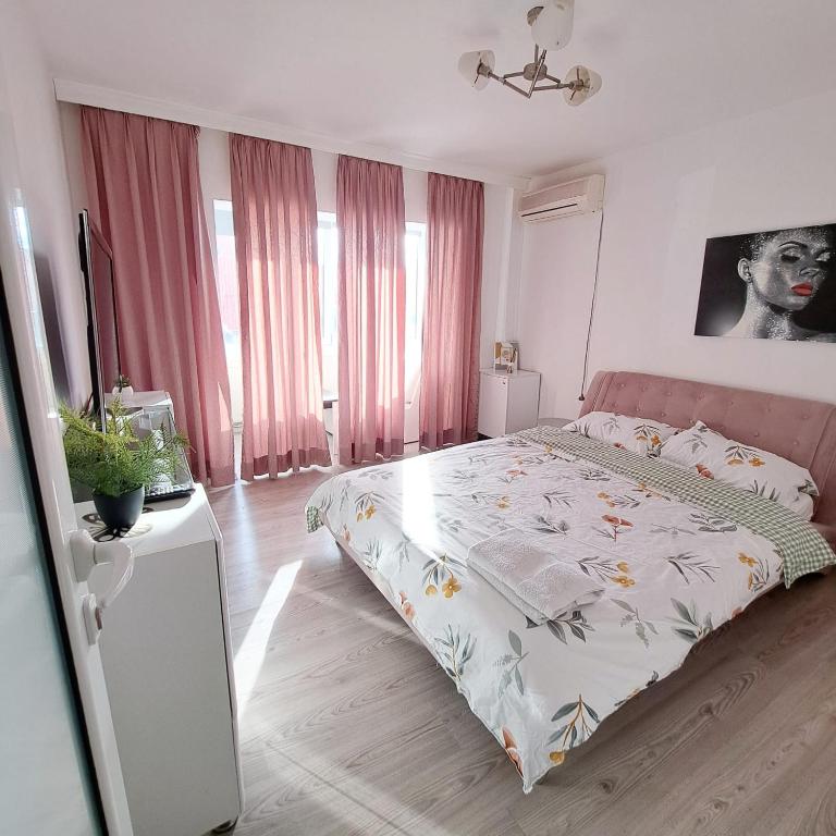 - une chambre dotée d'un lit avec un couvre-lit floral dans l'établissement Apartament Elegant - Zona Alfa, à Arad