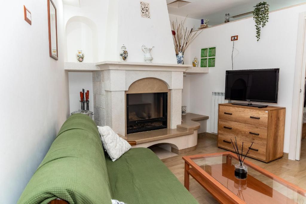 a living room with a green couch and a fireplace at Suite del Corso - Center & Comfort in Locorotondo