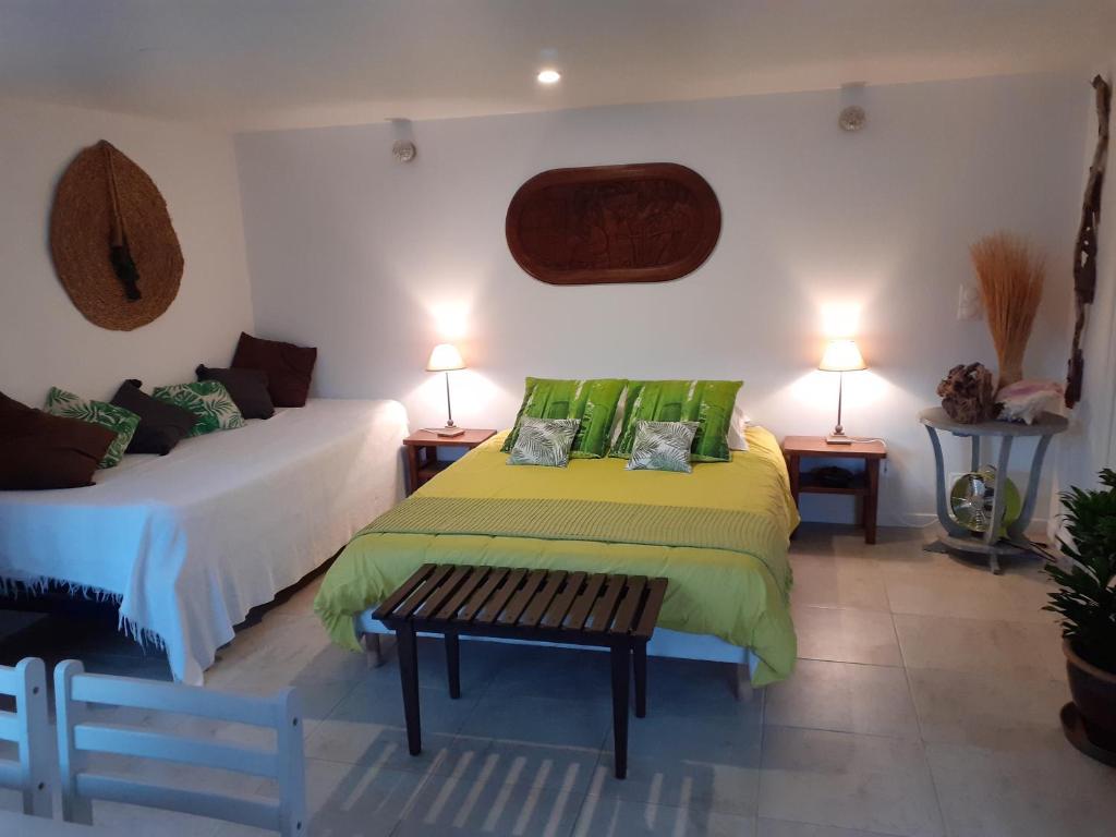 a bedroom with two beds with green pillows at Studio " LE FARE DES TERRES ROUGES" Dans L AUDE in Arques