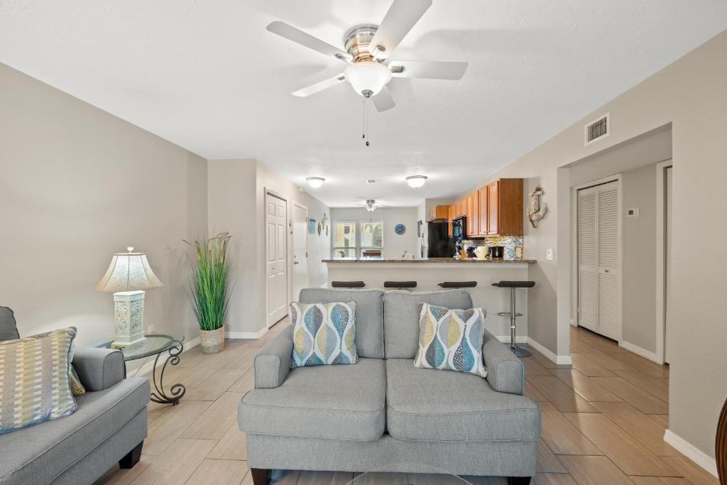 een woonkamer met een bank en een plafondventilator bij Cozy 2-Bedroom Condo in Prime Siesta Key Location in Sarasota