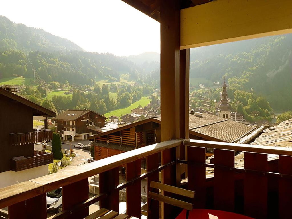 Elle comprend un balcon offrant une vue sur la ville et les montagnes. dans l'établissement Duplex skis aux pieds centre village - 6 couchages - 2 salles de bain, à La Clusaz