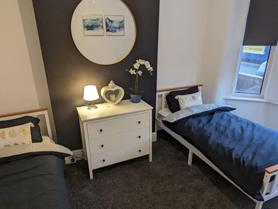 1 dormitorio con 2 camas y vestidor con espejo en The road to Wigan Pier en Pemberton