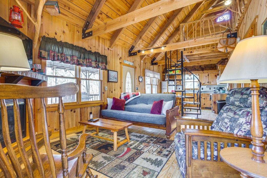 - un salon avec un canapé et une table dans une cabine dans l'établissement Quaint Dahlonega Cabin with Cavenders Creek Access!, à Dahlonega