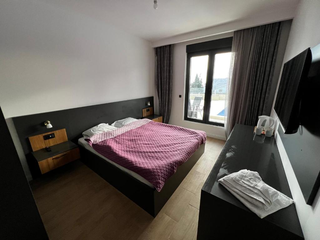 a small bedroom with a bed and a window at Elia Hotel Residence in Budva