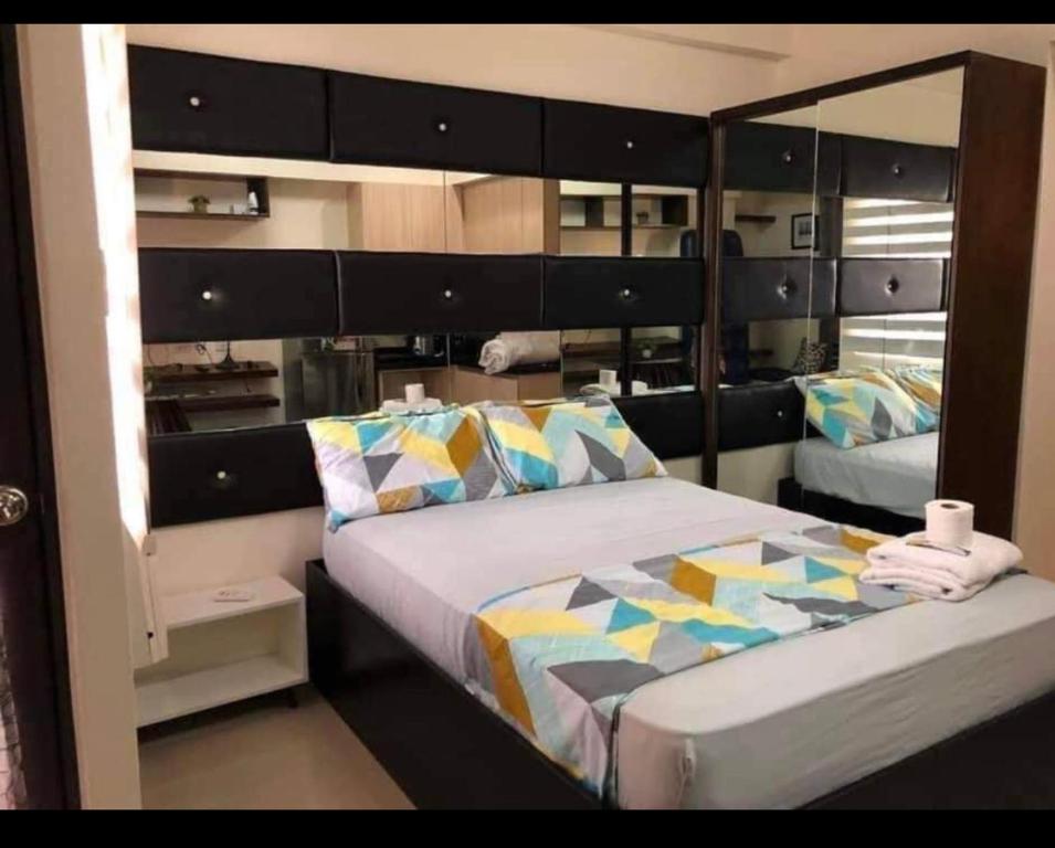 a bedroom with a bed with a large mirror at Condo units in Mabolo Garden Flats Cebu in Cebu City