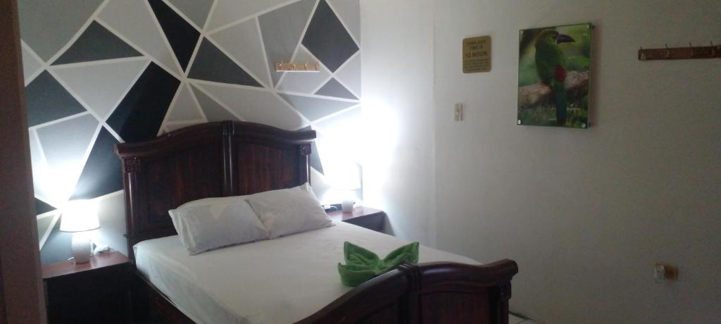 1 dormitorio con 1 cama con pared geométrica en Aracari Inn Mindo en Mindo