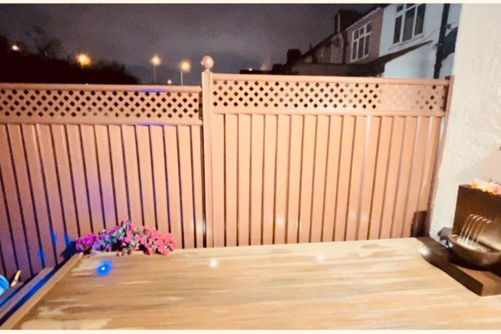 a wooden fence with a vase of flowers on a balcony at Casa Marina- 4 bedroom house with garden and balcony in Golders Green
