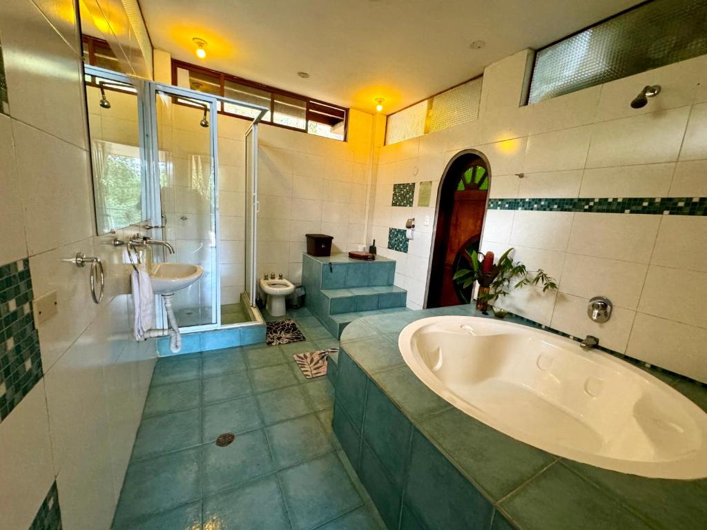 een grote badkamer met een bad en een wastafel bij Wisdom Forest Lodge in Tena