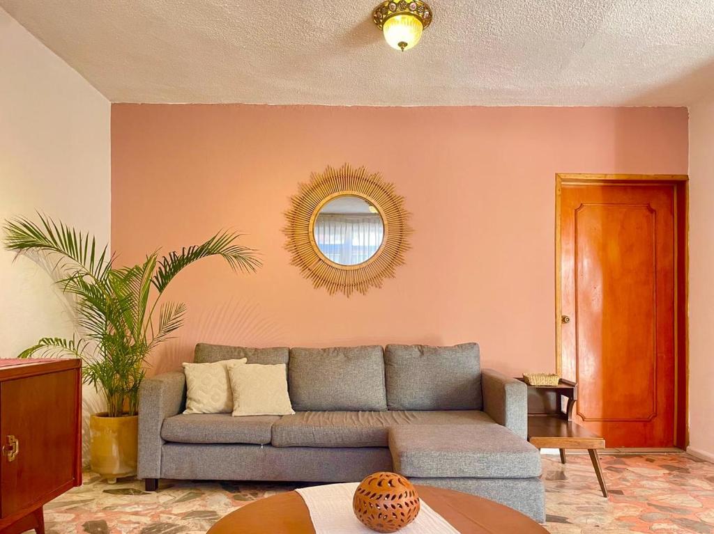 un soggiorno con divano e specchio di Spacious artsy home with fast WiFi a Città di Oaxaca