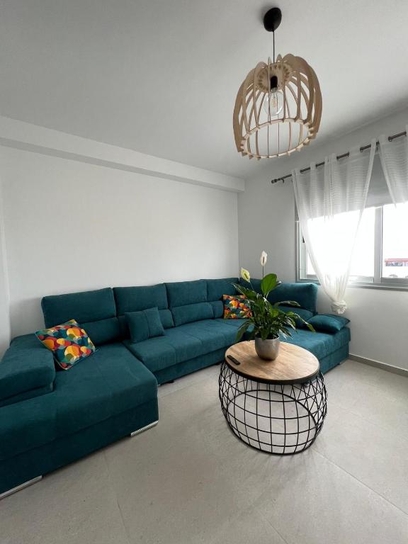 a living room with a blue couch and a table at Lola in Gran Tarajal