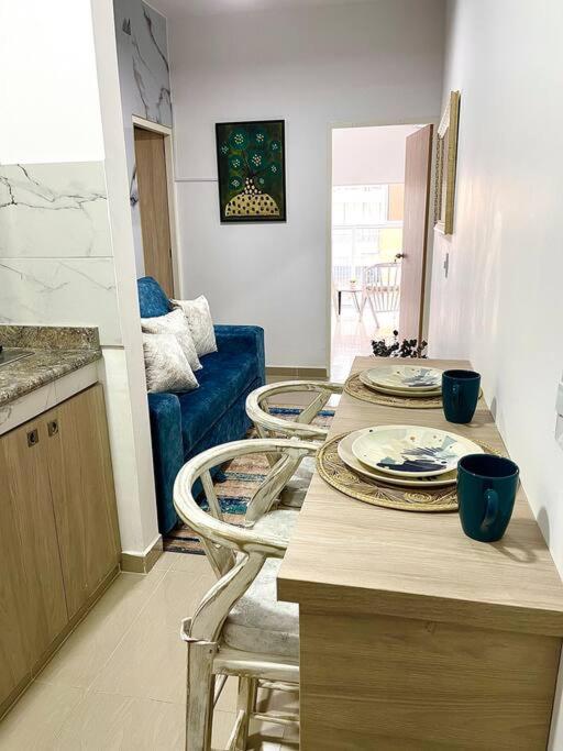 eine Küche mit zwei Stühlen und einem Tisch mit Tellern darauf in der Unterkunft BRR LIMONAR - Nuevo, Cómodo y hermoso aparta estudio 301 in Cali