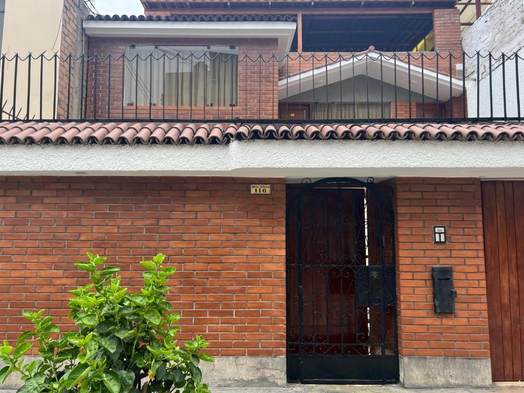 ein Backsteingebäude mit einem Tor und einem Balkon in der Unterkunft San Miguel, precioso depa 3 camas, internet y cable in Lima