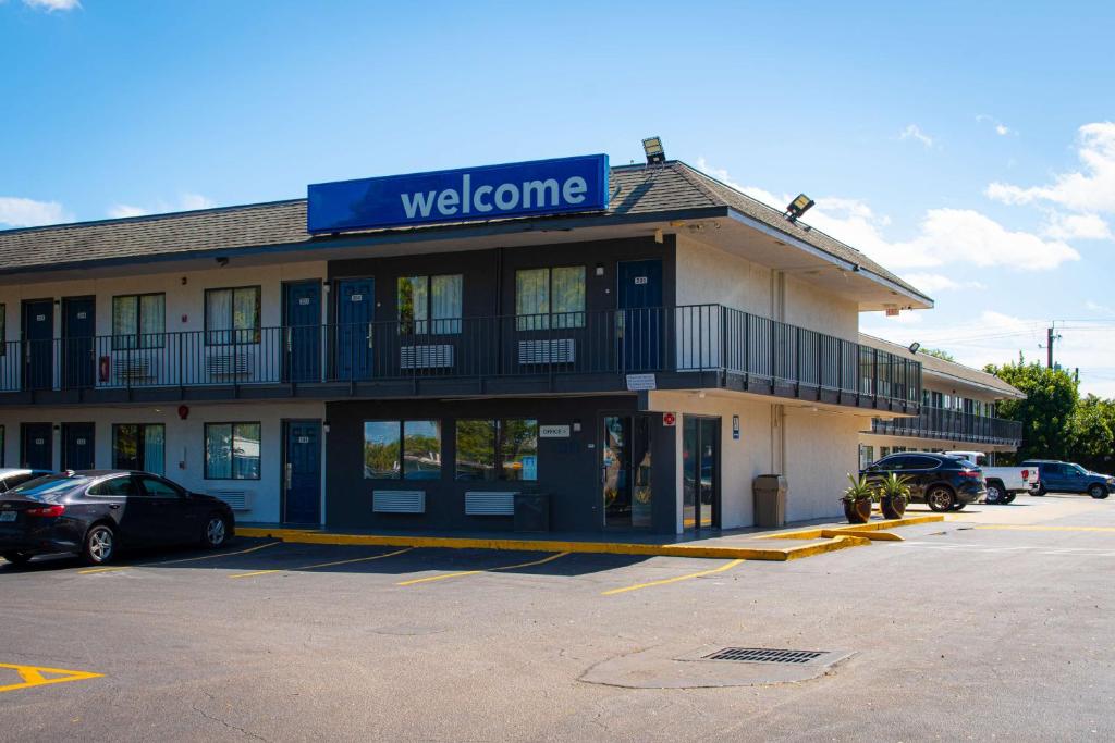- un bâtiment avec un panneau de bienvenue en haut dans l'établissement Motel 6-Lantana, FL, à Lantana