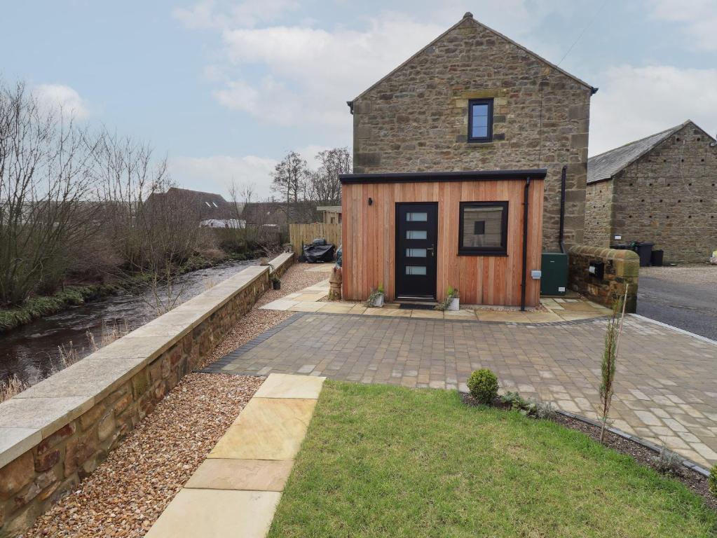 a home with a stone house with a driveway at Rowan Barn in Hexham