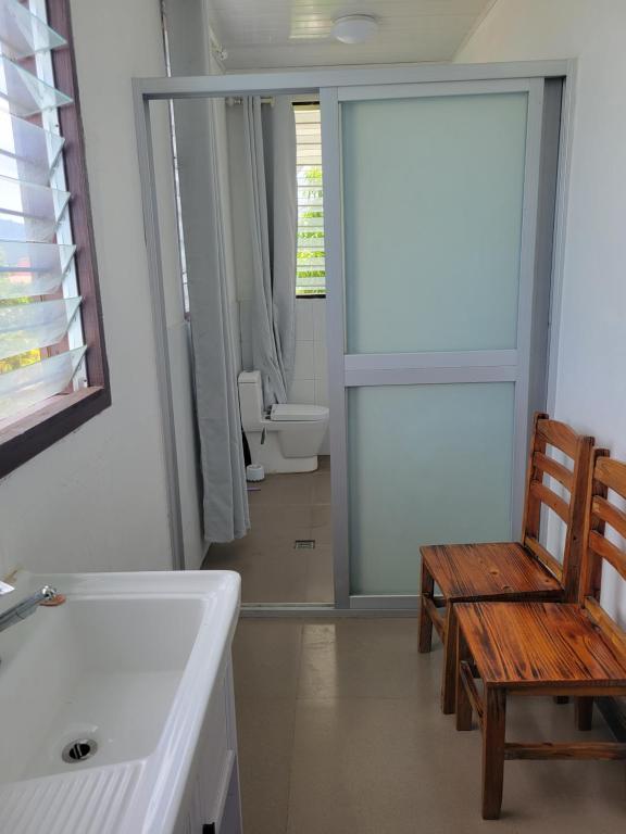 ein Badezimmer mit einem Waschbecken, einer Bank und einem WC in der Unterkunft Chinese family kingdom in Nadi