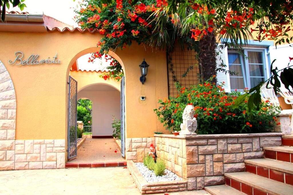 uma entrada para uma casa com um arco com flores em Casa Bellavista em Banjole