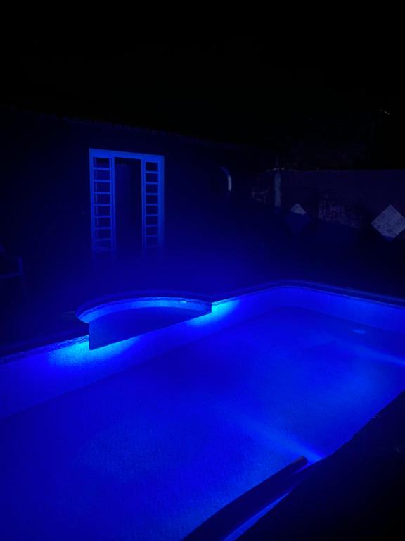 una piscina en una habitación oscura con luces azules en recanto Gonzales, en Sarapuí