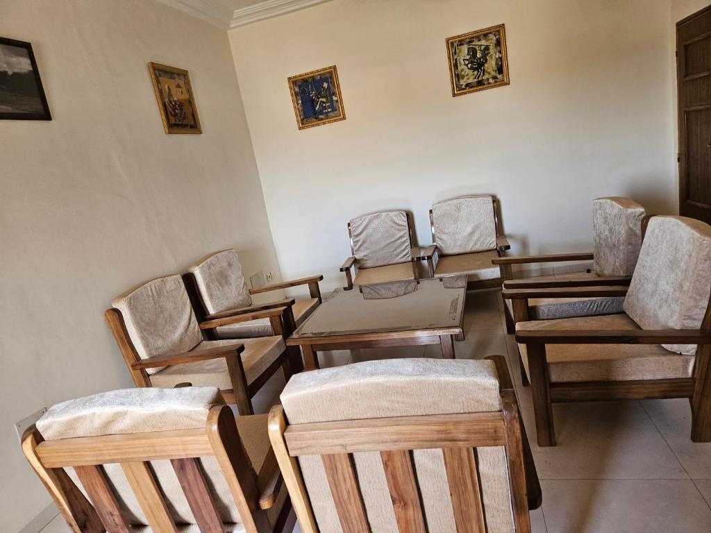 eine Gruppe von Stühlen und Tischen in einem Zimmer in der Unterkunft Hébergement VIP in Ouagadougou