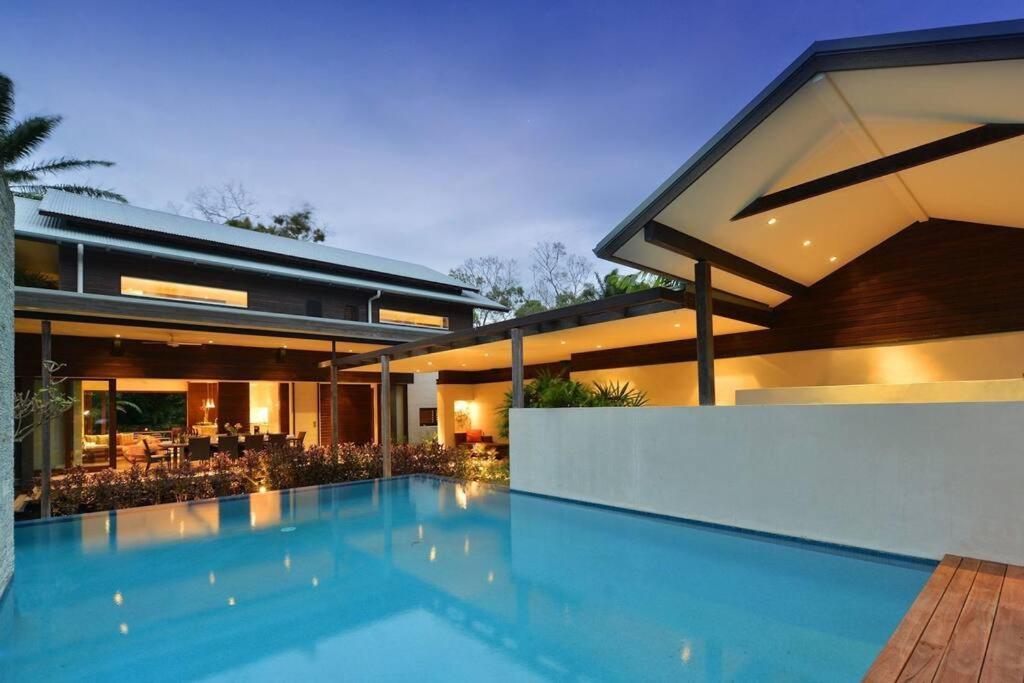 una gran piscina frente a una casa en 6 Beachfront Mirage - Luxury 4 Bedroom Home, en Port Douglas