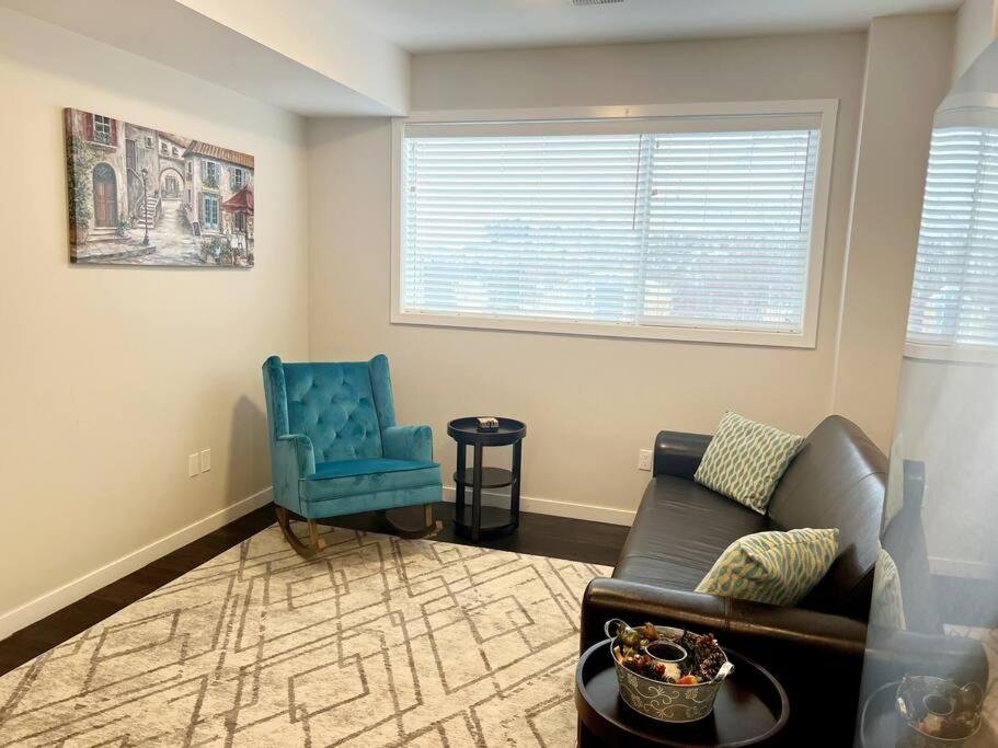sala de estar con sofá y silla azul en Your Cozy Retreat, 2BR suite en Kamloops