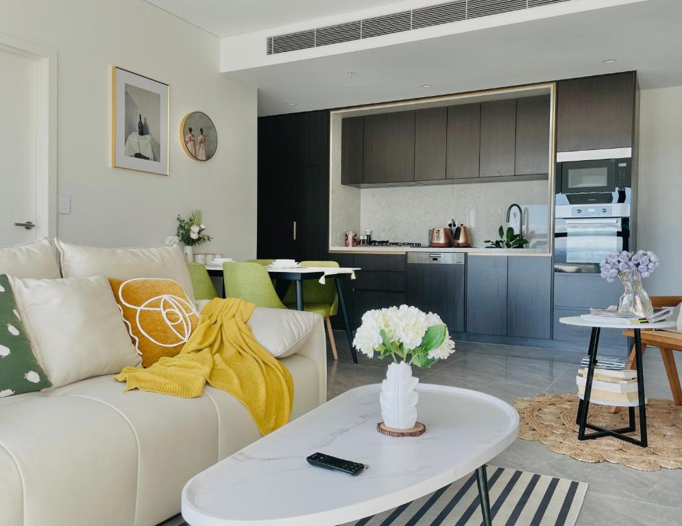 uma sala de estar com um sofá branco e uma mesa em Modern Apartment St Leonards em Sidney