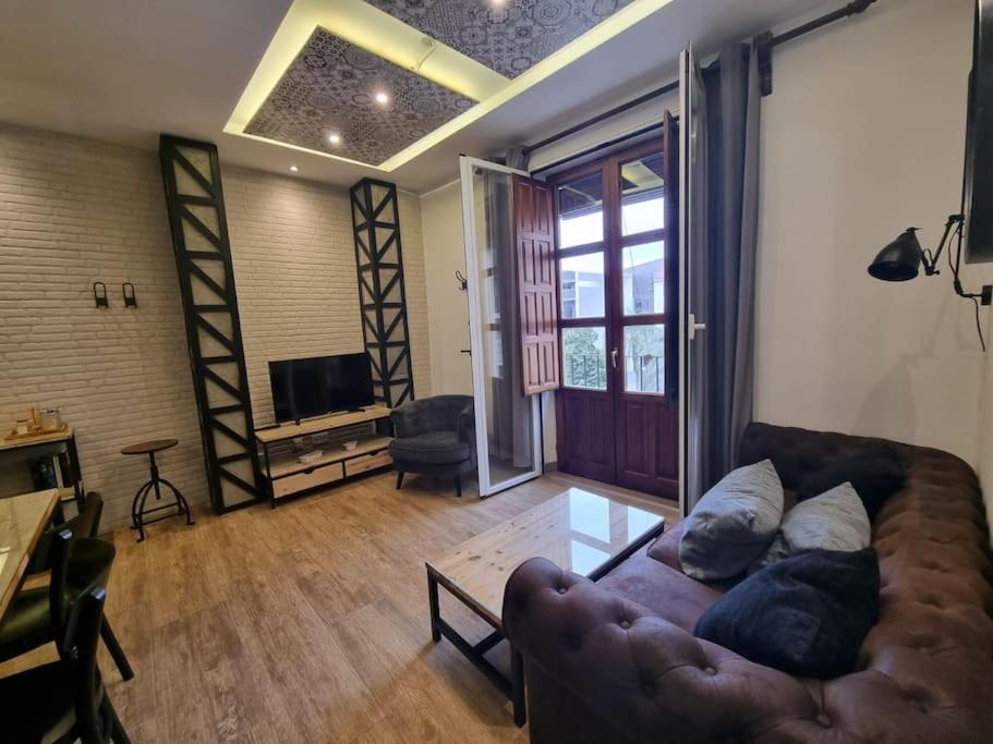 a living room with a couch and a television at Exclusividad a Pie de la Torre de la Catedral in Granada