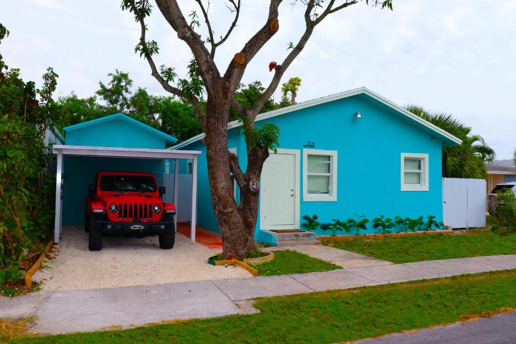 una casa azul con un jeep estacionado frente a ella en Caribbean Style House en Dania Beach