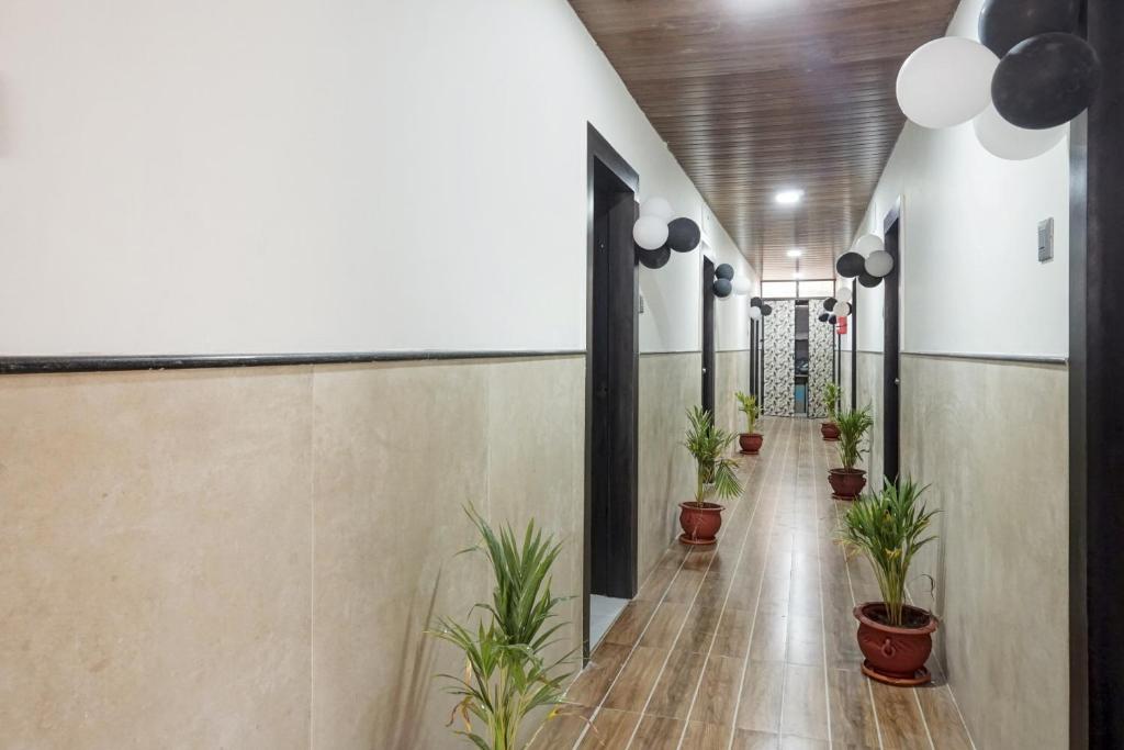 a corridor with potted plants in a building at OYO Hotel Rajyog in Wagholi