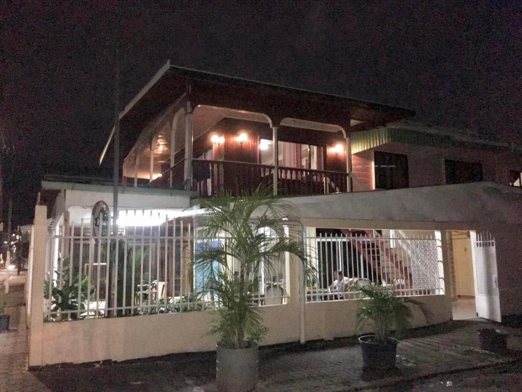 a large house with a balcony at night at Hotel Mangueira in Paramaribo