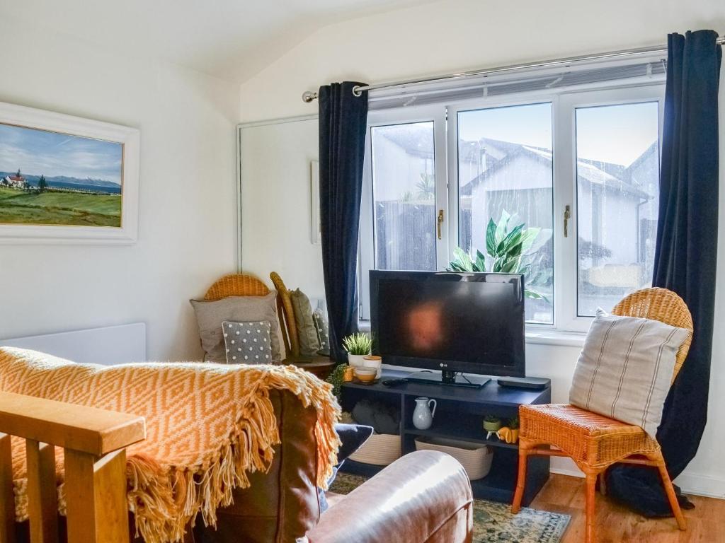 a living room with a couch and a tv at The Stables in Ayr