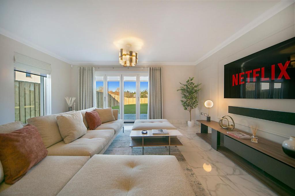 een woonkamer met een bank en een tv bij Luxury Hazledene Villa #14 - Grampian Lettings Ltd in Aberdeen