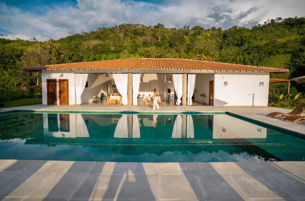 uma villa com piscina em frente a uma casa em Quinta San Felipe em Manizales