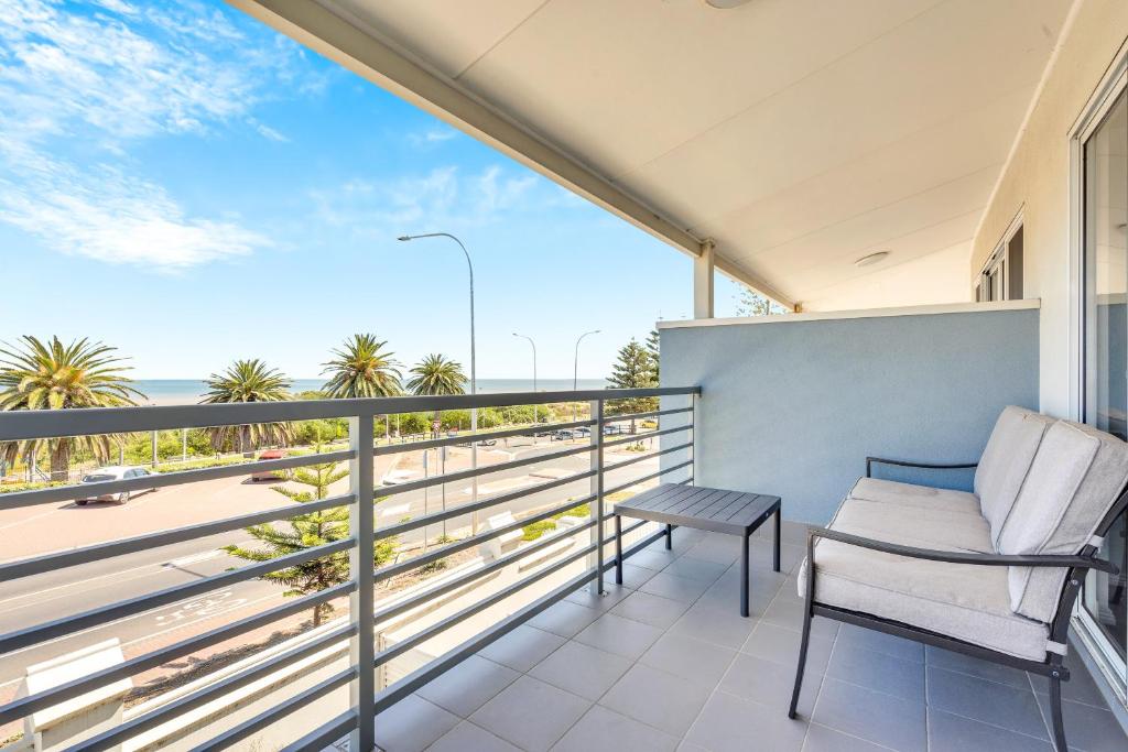 a balcony with a chair and a view of the ocean at 96B Esplanade, Semaphore in Semaphore