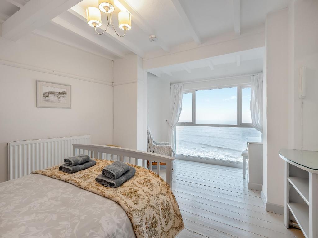 1 dormitorio con 1 cama y vistas al océano en Manderley, en Sheringham