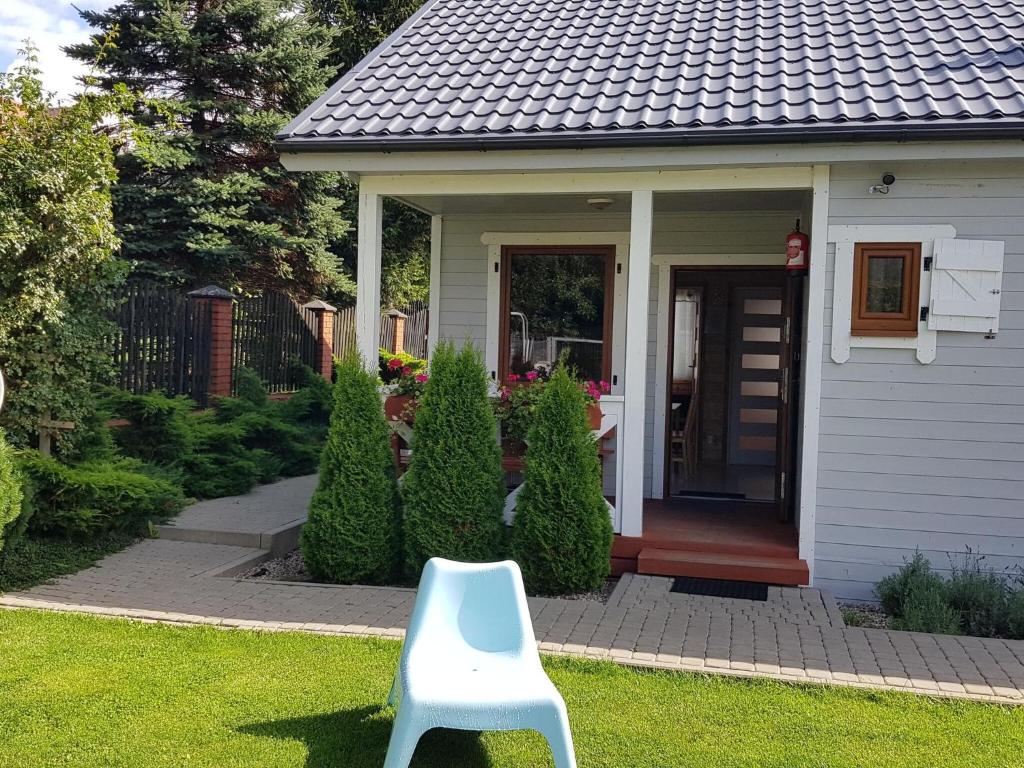 una silla blanca frente a una casa en Single-story holiday house, Siano ty, en Sianożęty