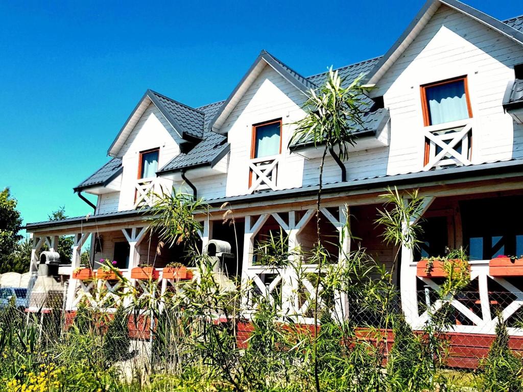 uma casa branca com uma cerca à frente. em Comfortable holiday cottages, Siano ty em Sianozety