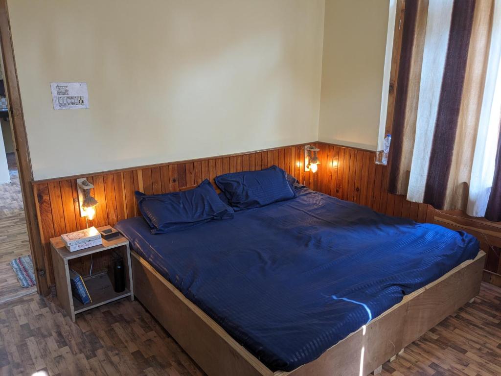 Nagar的住宿－Emma stays，一间卧室配有一张带蓝色床单的床和一张桌子。